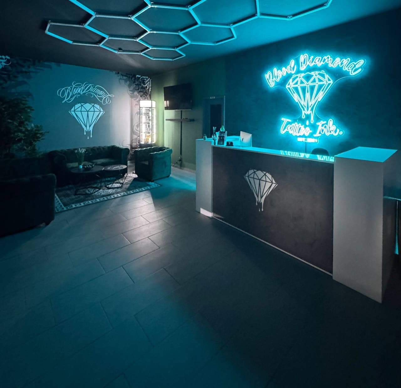 Empfangsbereich des Blood Diamond Tattoo Ink. – modernes Design mit Neonlogo und stilvoller Lounge-Atmosphäre.