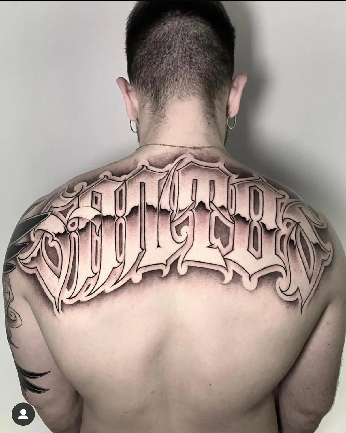 Chicano-Schrift-Tattoo am Rücken.