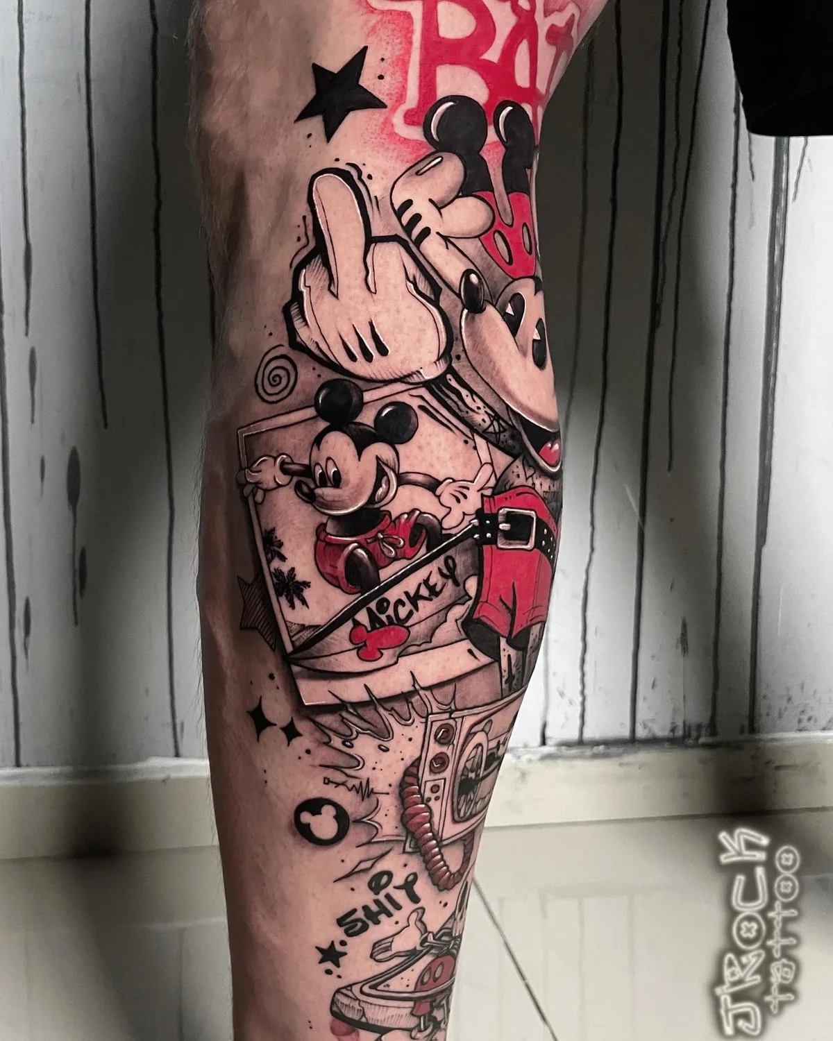 Schwarz-rotes Collage-Tattoo mit grafischen und typografischen Elementen.