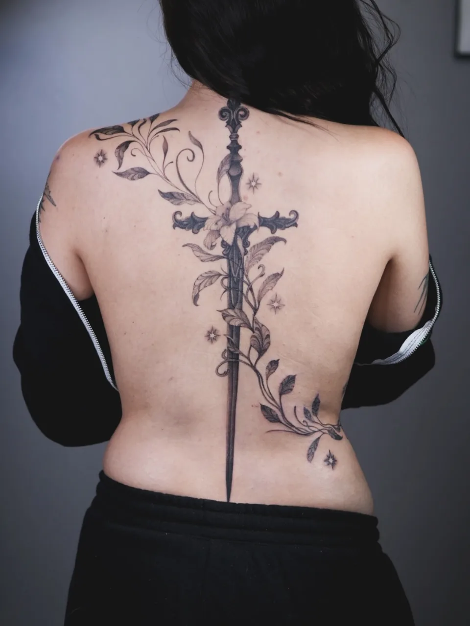 Fine Line Tattoo mit feinen Linien, floralen Elementen und dezenter Schattierung – Blood Diamond Tattoo Ink.
