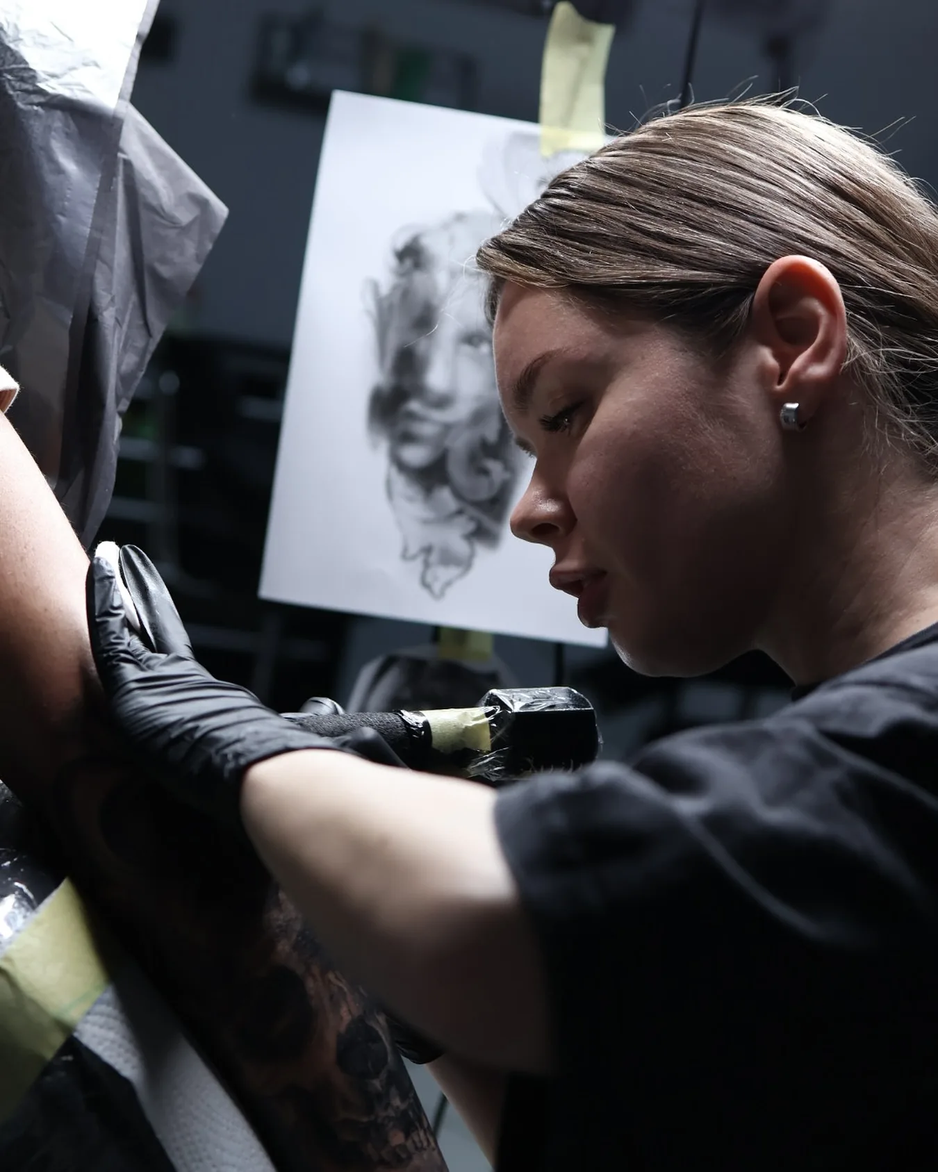 Tätowiererin bei konzentrierter Arbeit an einem Tattoo im Studio Heilbronn / Neckarsulm.