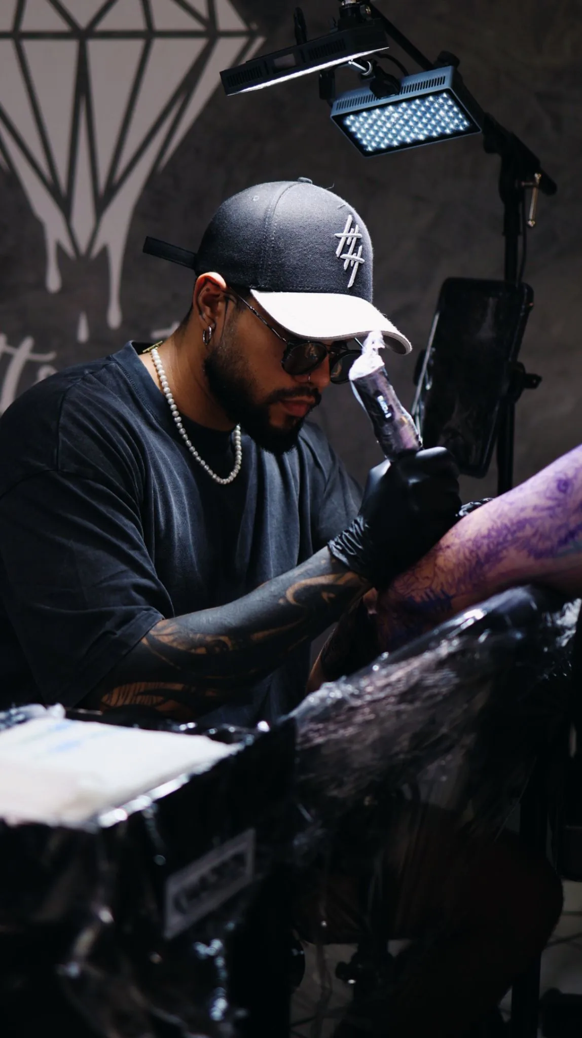 Tätowierer bei konzentrierter Arbeit an einem Tattoo im Studio Pforzheim / Ötisheim.
