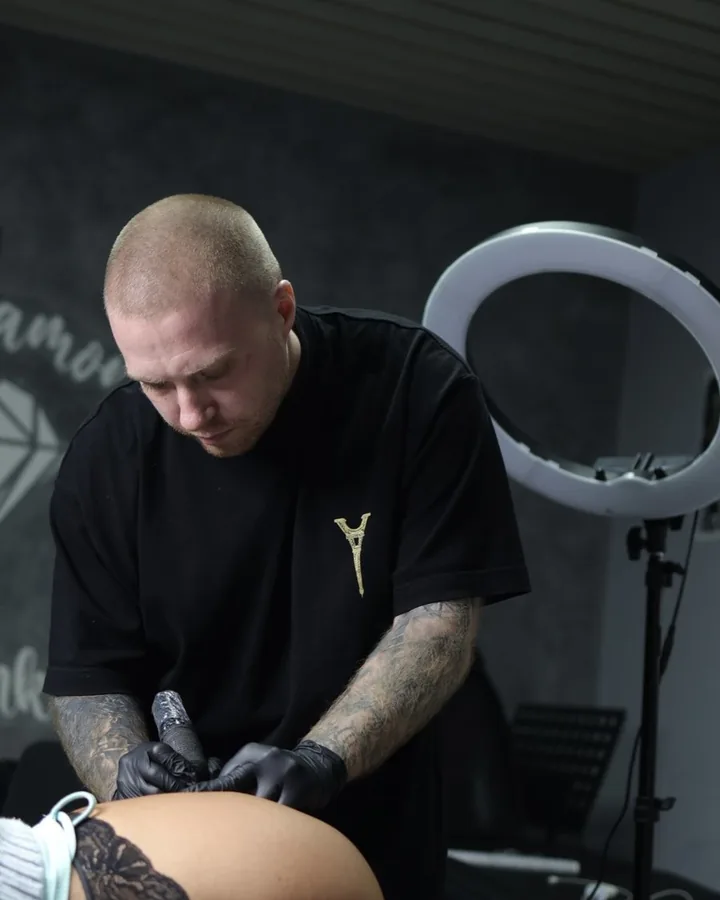 Ein Blood-Diamond-Artist tätowiert konzentriert im Studio.