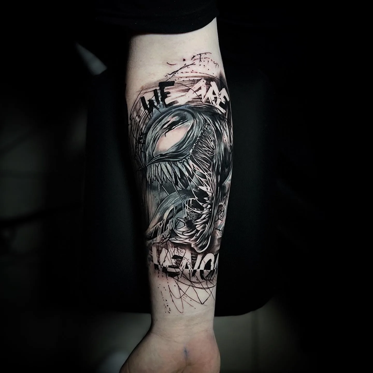 Schwarz-graues Venom-Tattoo mit Schriftzug „We are Venom“ am Unterarm.
