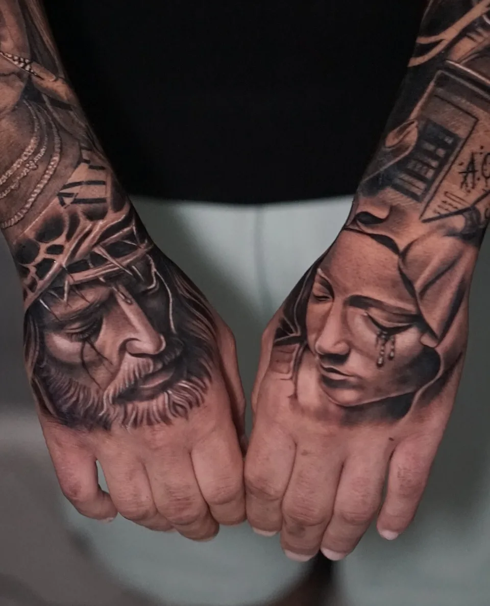 Jesus- und Marien-Porträts als Black-and-Grey-Tattoos auf beiden Handrücken.