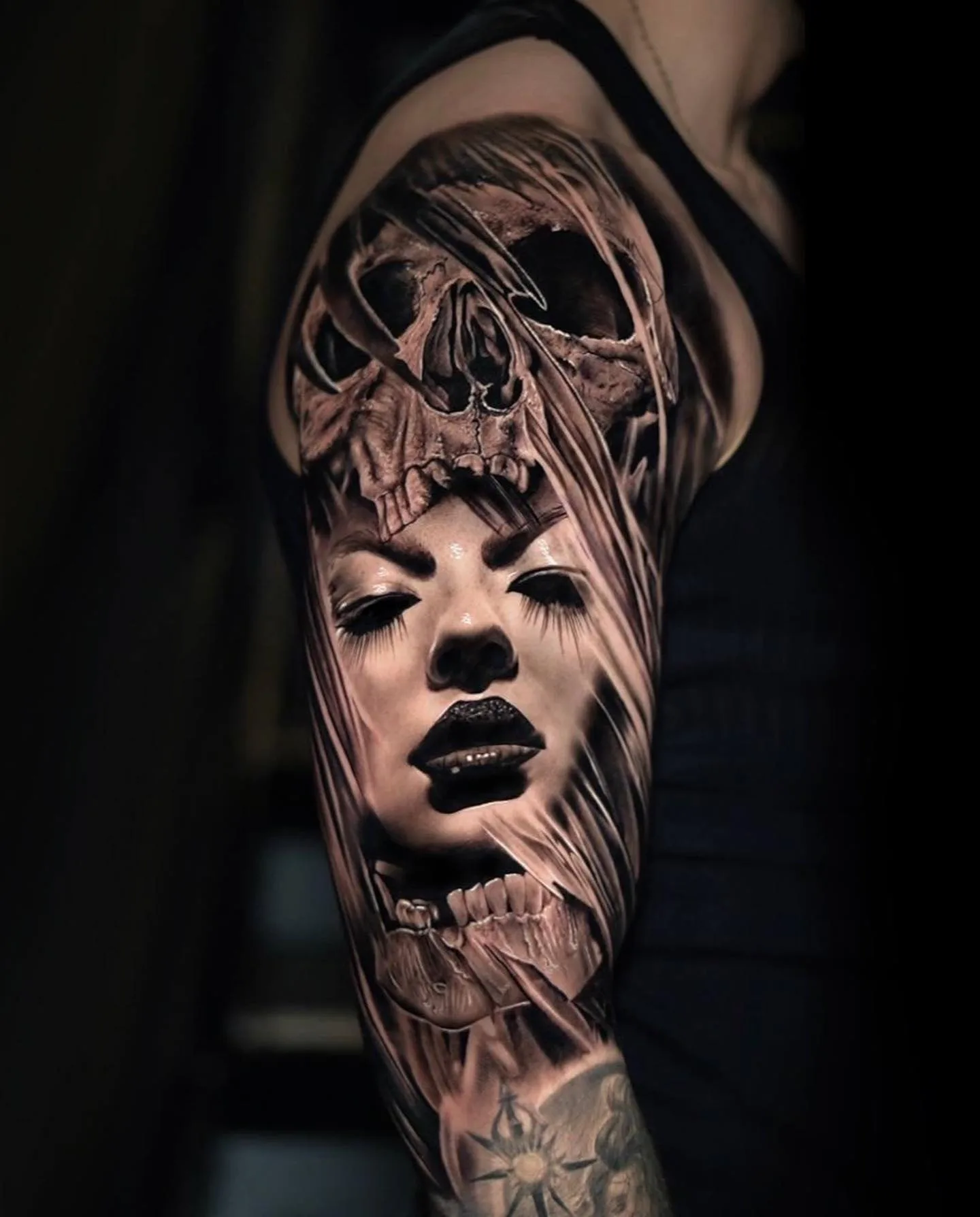 Frauenporträt verschmolzen mit einem Totenschädel, Realistic-Tattoo am Oberarm.